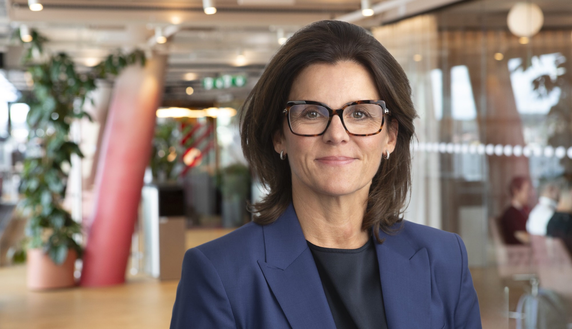 Anna Johnson, vd för Svenska Spel, i blå kavaj och glasögon i en kontorsmiljö.